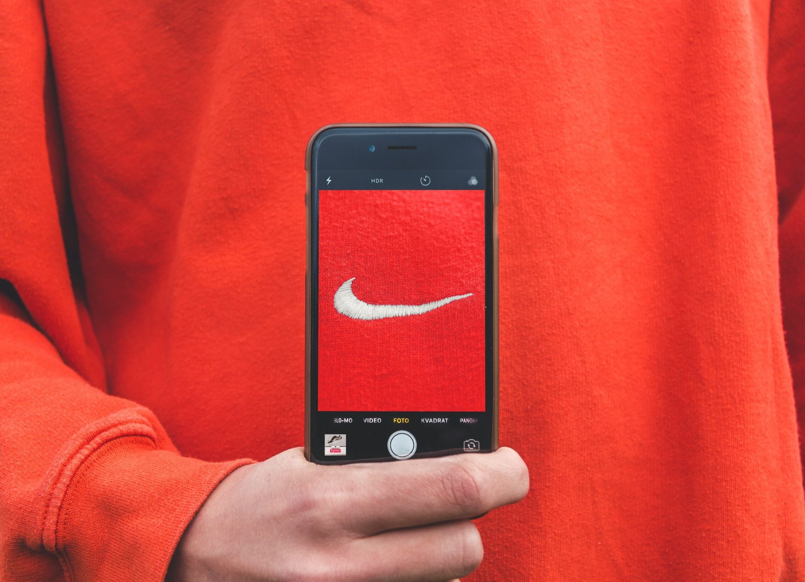 person holding iPhone taking picture on Nike label